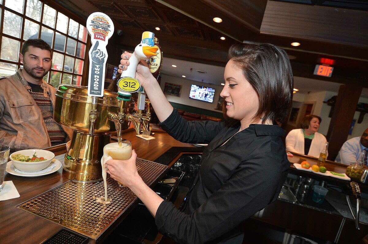 Hour Photo/Alex von Kleydorff Bartender Lianne Carpenter pours a cold beer at Bogey's Grille and Tap Room new location at Wilton Ave and Cross St. in Norwalk