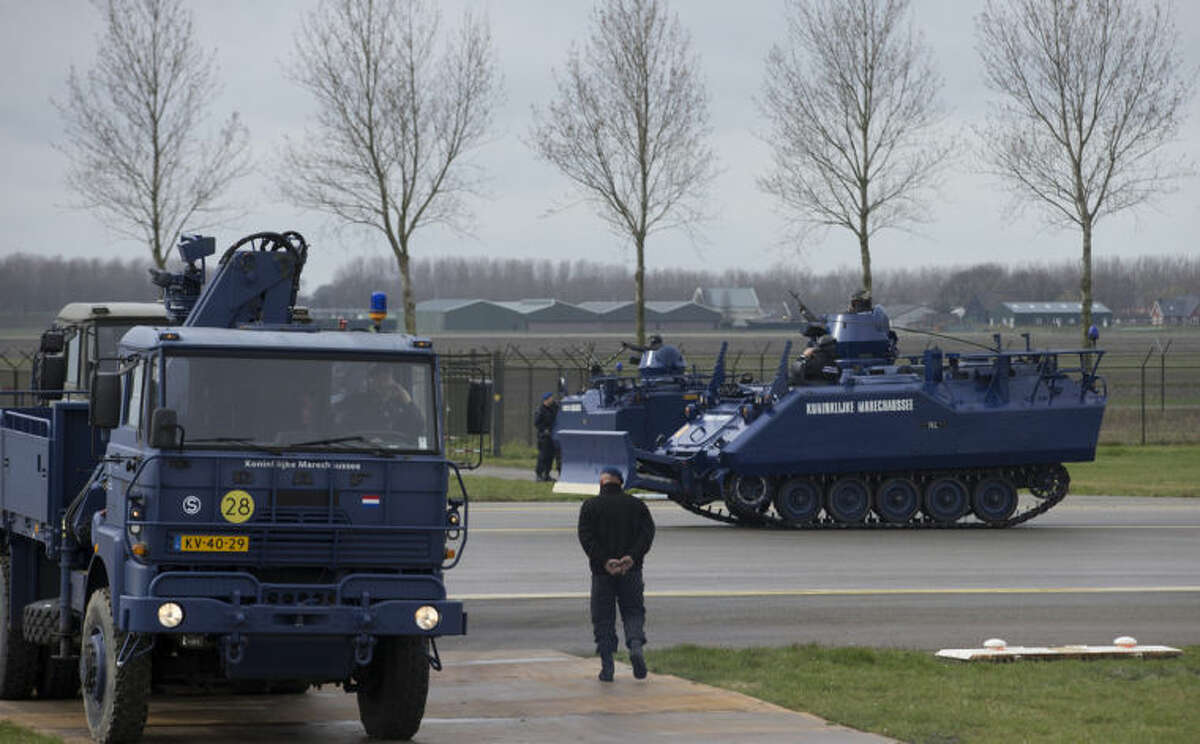 Dutch military police vehicles guard a section of Schiphol airport where China's President Xi Jinping is expected to arrive in Amsterdam, Netherlands, Saturday March 22, 2014. Xi is on a two-day state visit ahead of the March 24 and 25 Nuclear Security Summit in The Hague. (AP Photo/Peter Dejong, Pool)