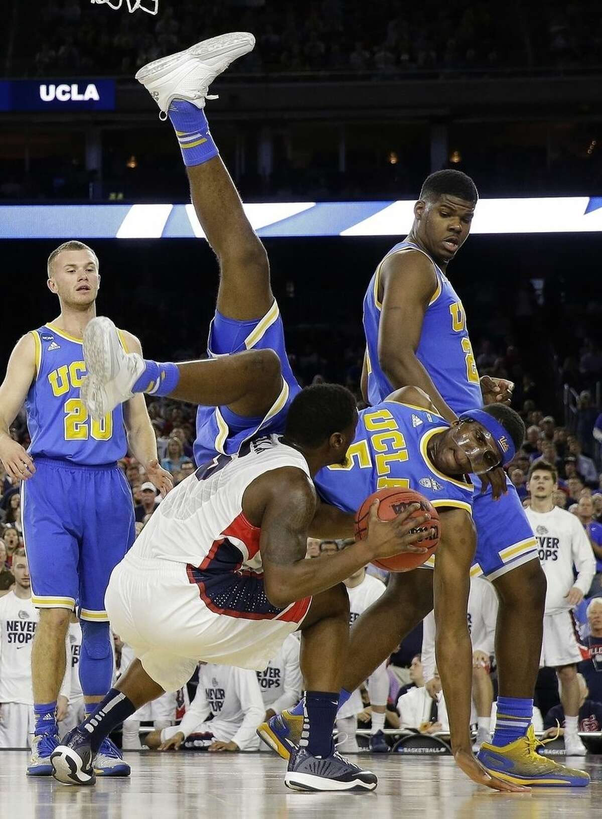UCLA's Kevon Looney (5) falls over Gonzaga's Gary Bell Jr. during the second half of a college basketball regional semifinal game in the NCAA Tournament Friday, March 27, 2015, in Houston. (AP Photo/David J. Phillip)