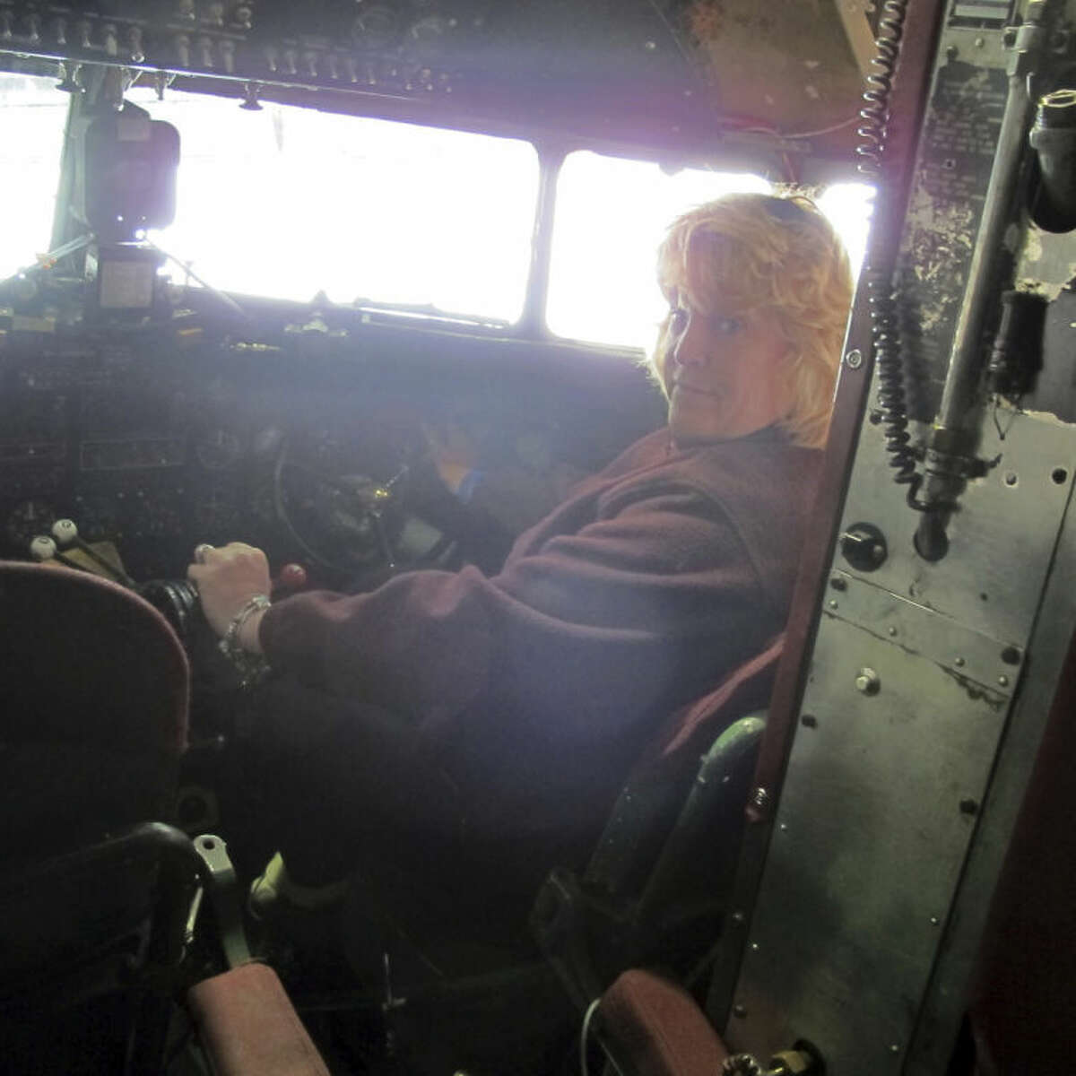 This photo taken March 6, 2014, shows pilot Naomi Wadsworth inside the cockpit of a World War II-era Douglas C-47, housed at the National Warplane Museum in Geneseo, N.Y. At the invitation of the French government, the airplane will return to France in June to participate in celebrations marking the 70th anniversary of the D-Day invasion of Normandy. The airplane, known as Whiskey 7 because of its markings, is one of the original troop carriers that dropped paratroopers in advance of the amphibious invasion. In June it will recreate its role and drop paratroopers over the original drop zone in Sainte-Mere-Eglise. (AP Photo/Carolyn Thompson)