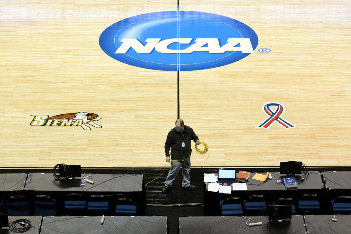 James Anilowski, an information technology professional, installs ethernet cables along radio radio row for broadcasters at the NCAA women's basketball tournament Thursday, March 26, 2015, at the Times Union Center in Albany, N.Y. Connecticut takes on Texas, and Dayton takes on Texas, in the regional semifinals on Saturday, March 28. (AP Photo/The Daily Gazette, (AP Photo/The Daily Gazette, Patrick Dodson) TROY, SCHENECTADY; SARATOGA SPRINGS; ALBANY AND AMSTERDAM OUT