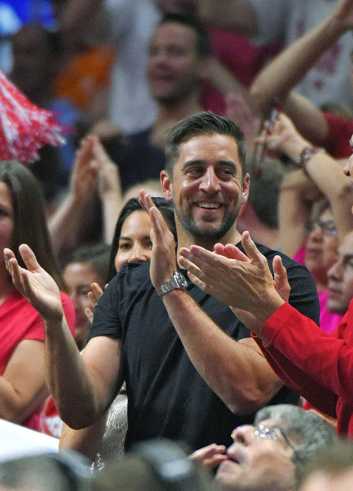 Aaron Rodgers, quarterback for the Green Bay Packers NFL football team, cheers during the second half of a college basketball regional final between Wisconsin and Arizona in the NCAA Tournament, Saturday, March 28, 2015, in Los Angeles. (AP Photo/Mark J. Terrill)