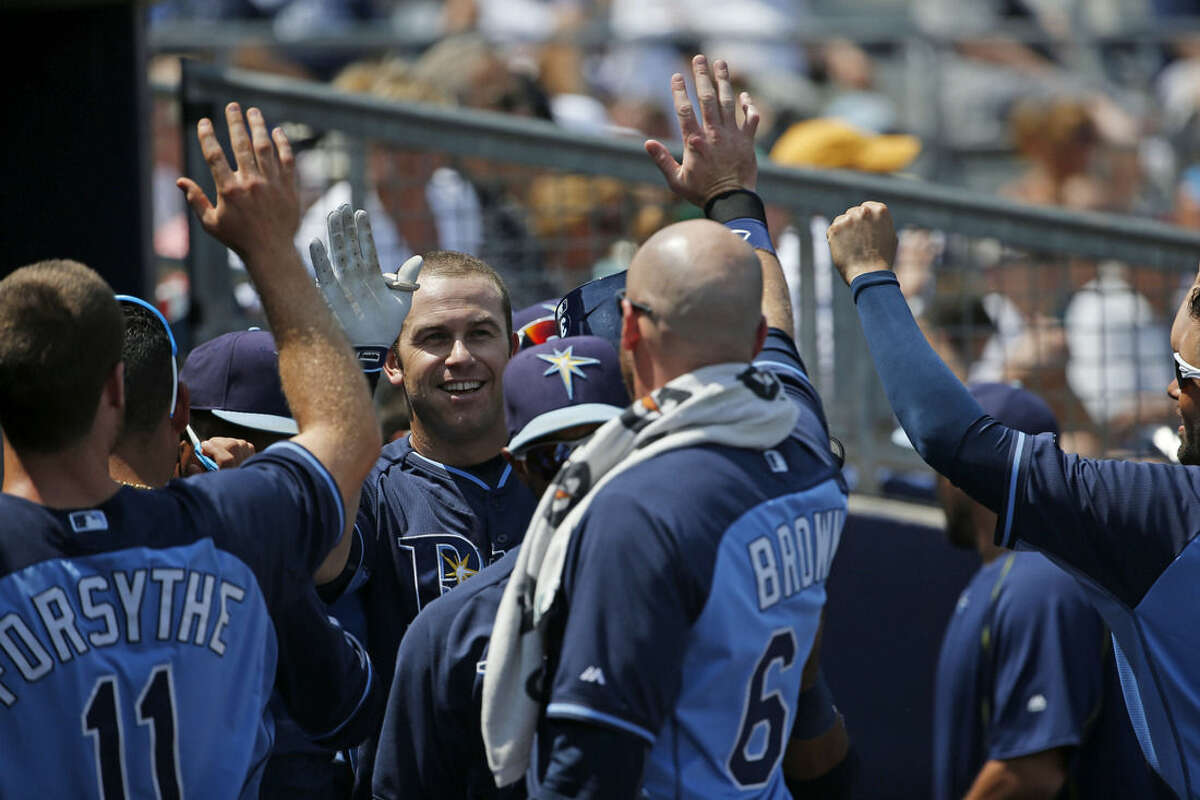 Tampa Bay Rays Evan Longoria, center, high-fives his teammates after scoring a run in the second inning during an exhibition spring training baseball game against the New York Yankees, Thursday, March 26, 2015, in Port Charlotte, Fla. The Rays won 6-5. (AP Photo/Brynn Anderson)