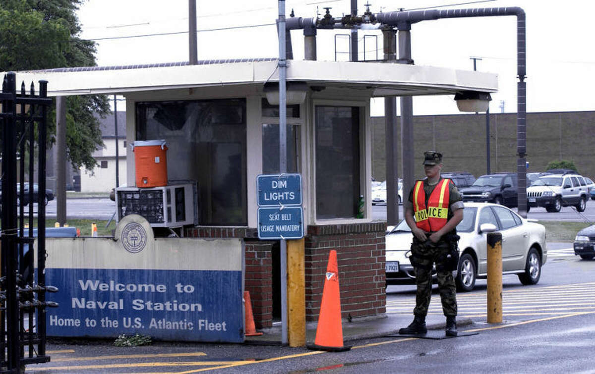 FILE - In this May 3, 2004 file photo, security personnel wait to inspect vehicles entering Norfolk Naval Station in Norfolk, Va. A sailor was fatally shot at the world's largest naval base late Monday, March 24, 2014, and security forces killed a male civilian suspect, base spokeswoman Terri Davis said. (AP Photo/The Virginian-Pilot, Mort Fryman)