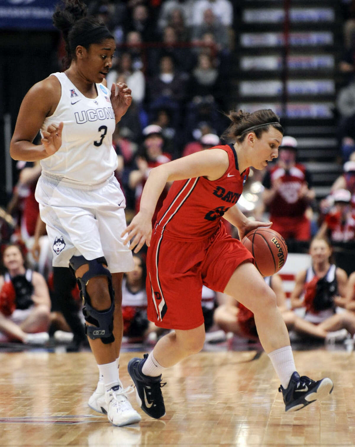 Dayton guard Andrea Hoover, right, dribbles past Connecticut forward Morgan Tuck (3) during the first half of a regional final game in the NCAA women's college basketball tournament on Monday, March 30, 2015, in Albany, N.Y. (AP Photo/Tim Roske)