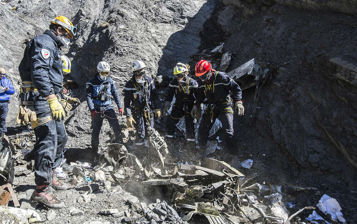 In this photo taken on Tuesday, March 31, 2015 and provided by the French Interior Ministry, French emergency rescue services work among debris of the Germanwings passenger jet at the crash site near Seyne-les-Alpes, France. The heads of Lufthansa and its low-cost airline Germanwings are visiting the site of the crash that killed 150 people amid mounting questions about the co-pilot and how much his employers knew about his mental health. (AP Photo/Yves Malenfer, Ministere de l'Interieur)