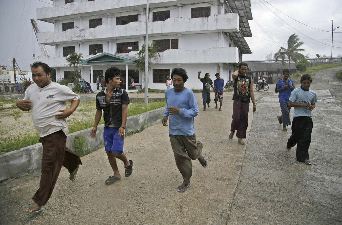 Burmese fishermen run to collect their belongings after being informed that they can leave, at the compound of Pusaka Benjina Resources fishing company in Benjina, Aru Islands, Indonesia, Friday, April 3, 2015. Hundreds of foreign fishermen on Friday rushed at the chance to be rescued from the isolated island where an Associated Press report revealed slavery runs rampant in the industry. Indonesian officials investigating abuses offered to take them out of concern for the men's safety. (AP Photo/Dita Alangkara)