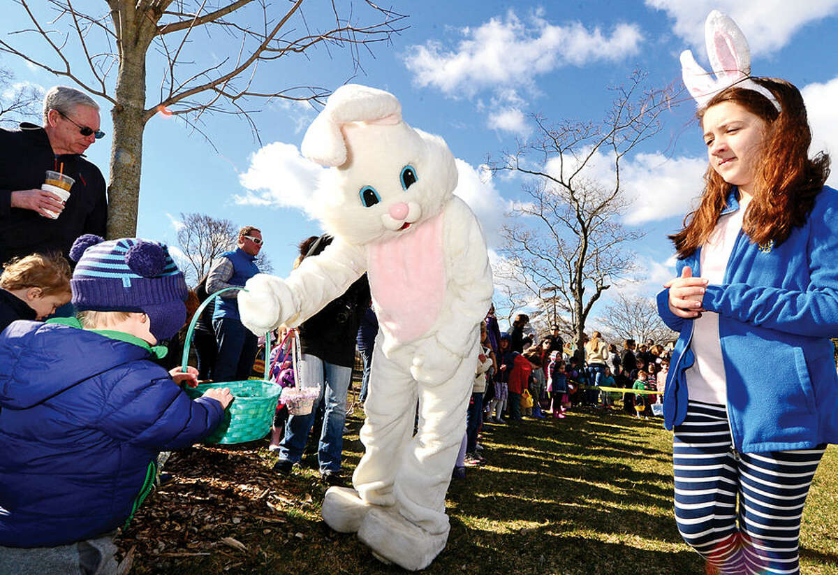 Hour photo / Erik Trautmann Farrell Aldrich helps the Easter Bunny distribute candy during The Rowayton Community Association’s annual Easter Egg Hunt Saturday at the Rowayton Community Center.