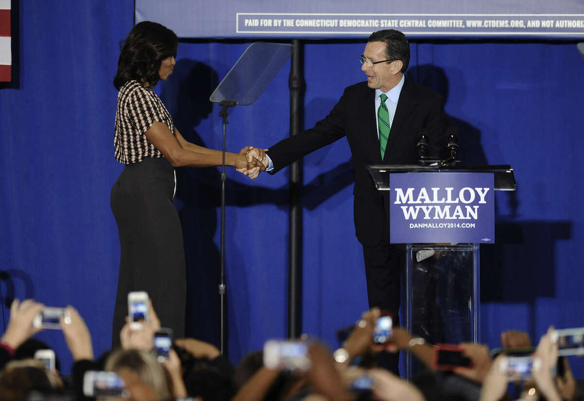 First lady Michelle Obama shakes hanks with Connecticut Gov. Dannel P. Malloy during a rally for Malloy, Thursday, Oct. 30, 2014, in New Haven, Conn. (AP Photo/Jessica Hill)