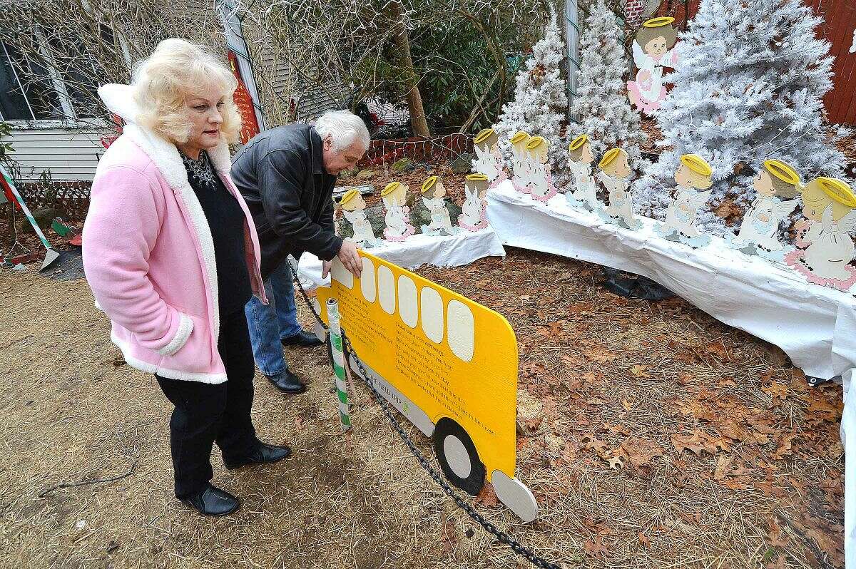 Hour Photo/Alex von Kleydorff Rick and Joan Setti will hold a tag sale to sell the items they have built and displayed over the last 26 Holiday's at their Norwalk home. Here they straighten a school bus full of angels that will be donated to Sandy Hook