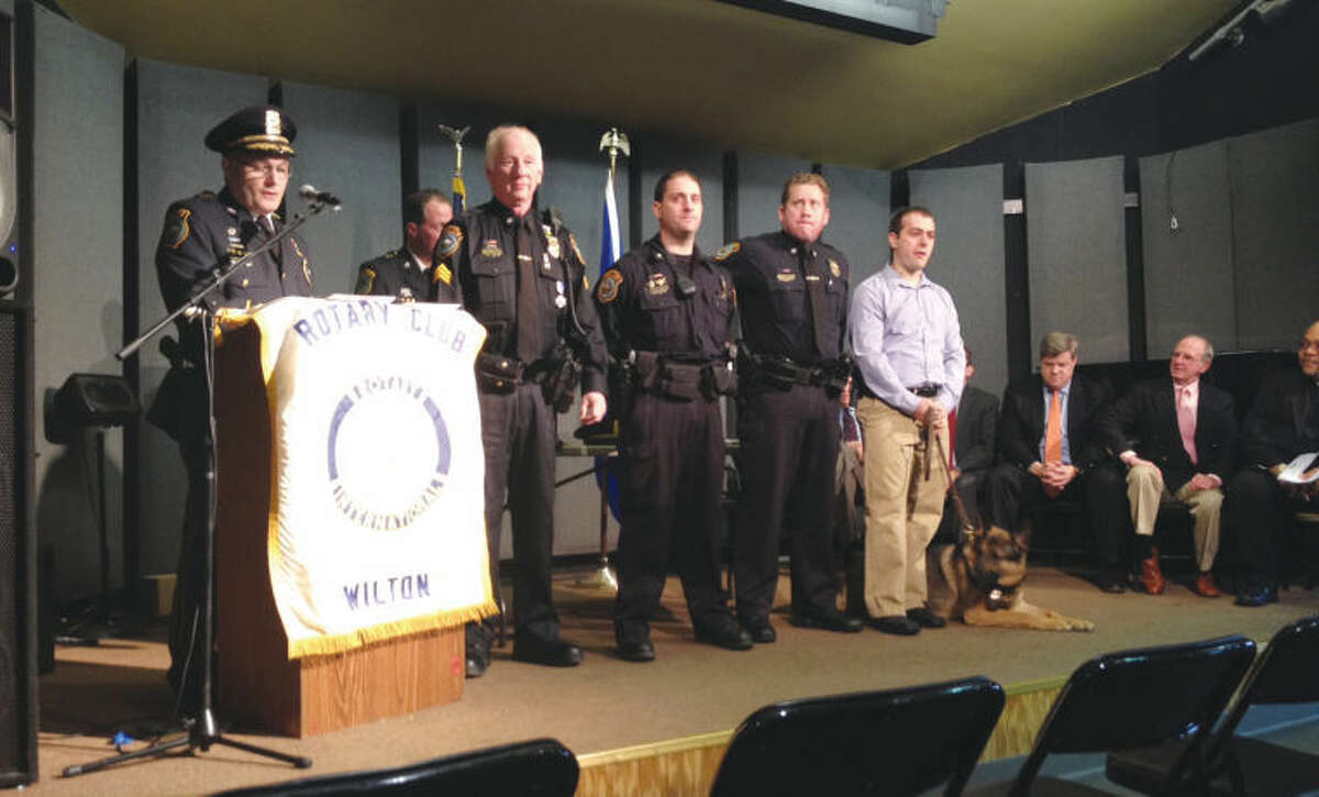 Pictured at the ceremony, from left to right are: Police Chief Michael Lombardo, Sgt. Thomas Tunney, Officer Tim Fridinger, Officer Michael Tyler, Officer Frank Razzaia, Canine Squad member Enzo; and seated are: police commissioners Chris Weldon and Donald Sauvigne. Capt. John Lynch is shown in the background.