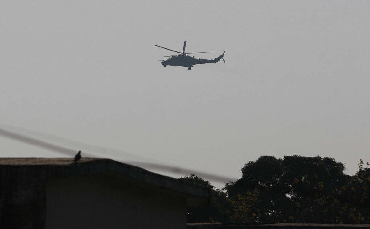 An Indian air force chopper on a reconnaissance mission flies over the Indian airbase in Pathankot, 430 kilometers (267 miles) north of New Delhi, India, Saturday, Jan. 2, 2016. At least four gunmen entered an Indian air force base near the border with Pakistan on Saturday morning and exchanged fire with security forces, leaving two of them dead, officials said. (AP Photo/Channi Anand)