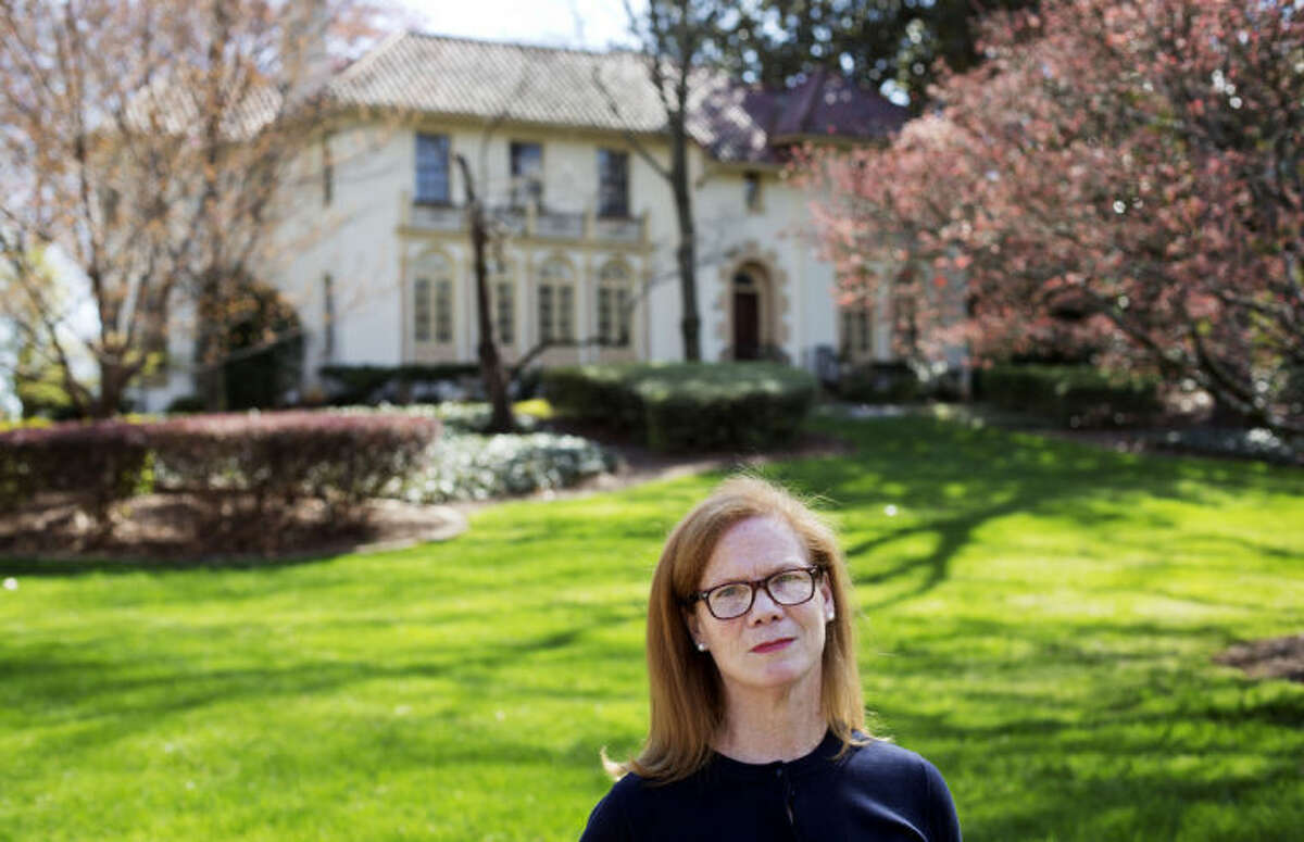 In this March 31, 2014 photo, Laura Mullins, a parishioner of Christ the King Cathedral, stands for a photo outside the former residence of Atlanta Archbishop Wilton Gregory, which will now be used as the church's rectory in Atlanta. Gregory apologized for spending $2.2 million on a mansion for his own personal use. The apology came after Pope Francis permanently removed a German bishop for his lavish spending on a renovation project. Mullins arranged a meeting with Gregory in January during which she and nine other Catholics asked him to sell the new mansion. (AP Photo/David Goldman)