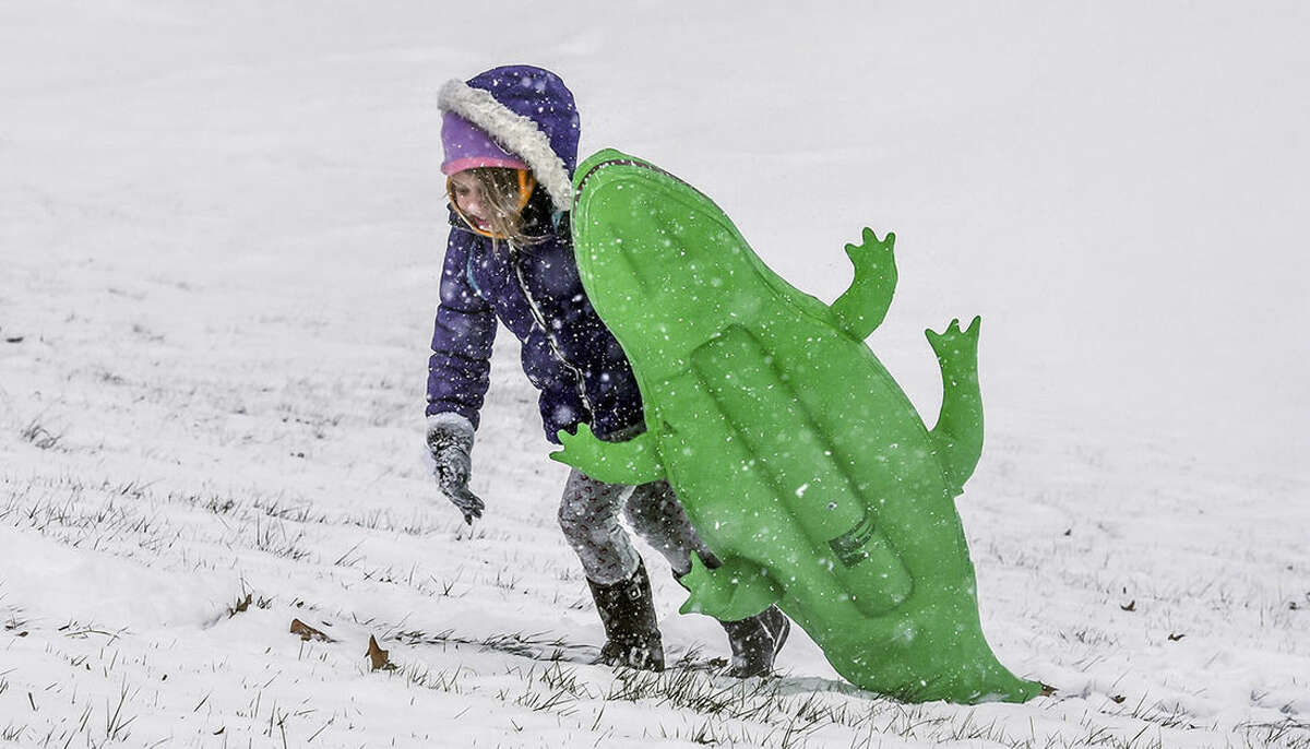 Kirah Jones carries a water inflatable Wednesday, Jan. 20, 2016, behind Danville High School in Danville, Ky. Snow and drizzle began falling early Wednesday across much of Kentucky and Tennessee leading school districts and some universities to cancel classes and officials to warn motorists to drive carefully. (Clay Jackson/The Advocate-Messenger via AP) TABLOIDS OUT; MANDATORY CREDIT