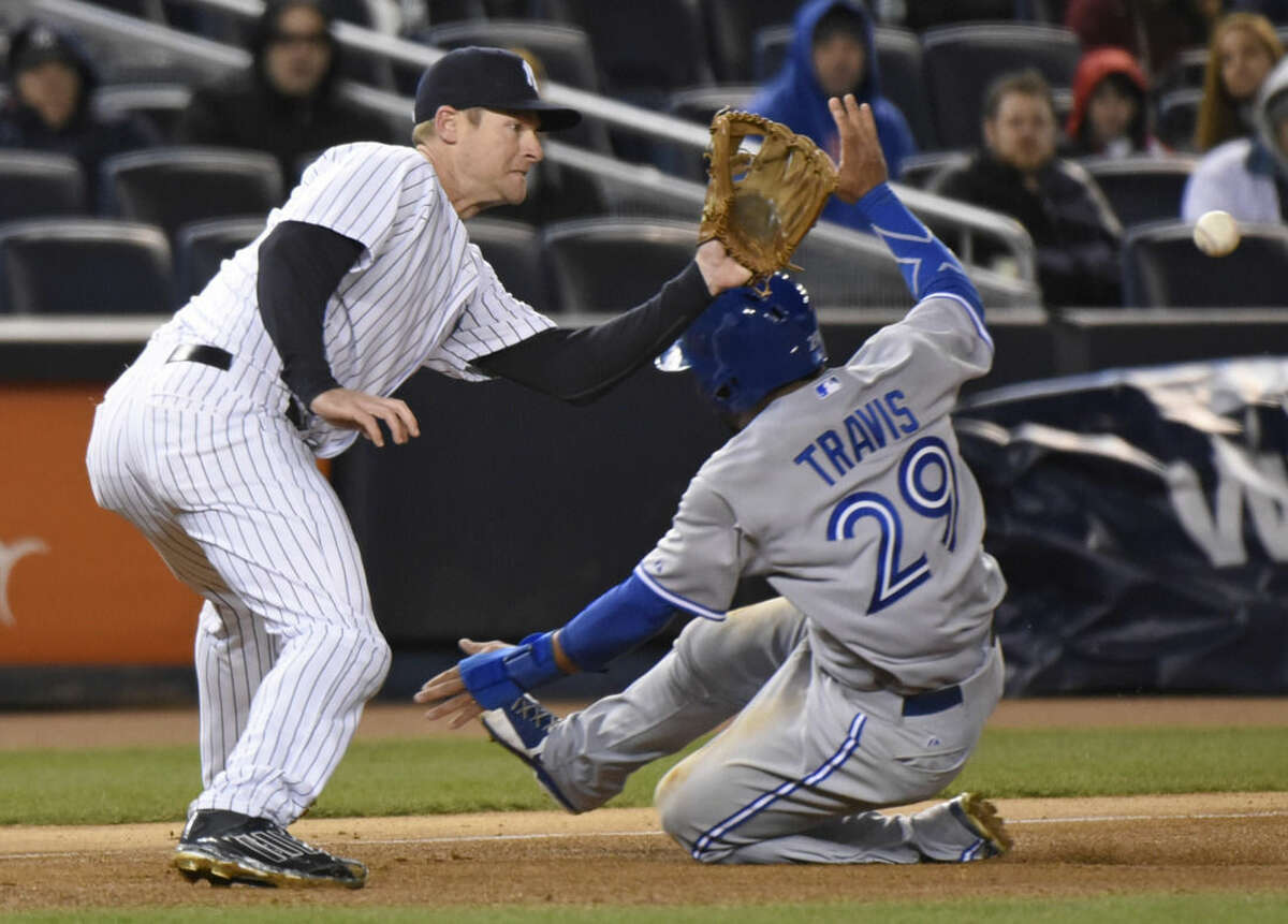 New York Yankees third baseman Chase Headley waits for the ball as Toronto Blue Jays' Devon Travis (29) slides into third base on a single by Blue Jays' Jose Reyes during the fifth inning of a baseball game Wednesday, April 8, 2015, at Yankee Stadium in New York. (AP Photo/Bill Kostroun)