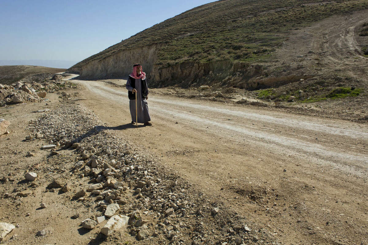In this Jan. 16, 2016 photo, a Palestinian walks on a newly-made section of a road that was financed by the European Union, on the outskirts of the West Bank village of Taqoa, near Bethlehem. Construction of the narrow country road has turned into a new battleground between Israel and the EU, deepening a dispute between the allies over Israeli settlement construction in the West Bank. The EU is paying for Palestinians to pave the dirt road as part of a broader effort to help them develop the local economy on the way to eventual independence. But Israel says the work is illegal and has ordered it to stop. (AP Photo/Nasser Nasser)
