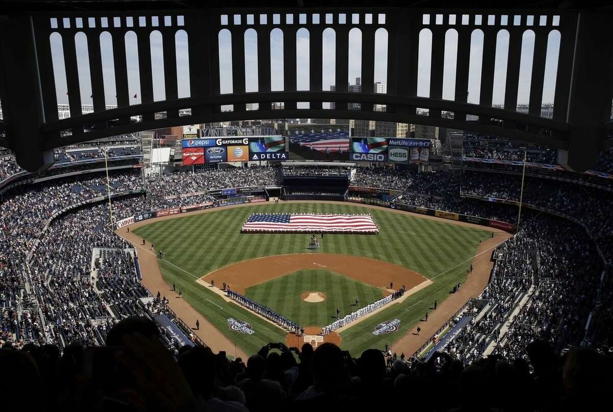 A large American flag is unfurled on the field before the opening day baseball game between the Toronto Blue Jays and the New York Yankees at Yankee Stadium, Monday, April 6, 2015 in New York. (AP Photo/Seth Wenig)