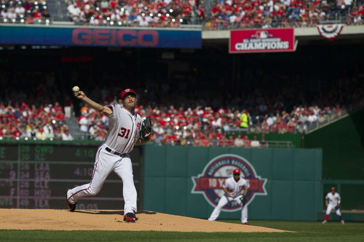 Washington Nationals starting pitcher Max Scherzer delivers his first pitch as a National against the New York Mets during the first inning of an opening day baseball game at Nationals Park on Monday, April 6, 2015, in Washington. (AP Photo/Evan Vucci)