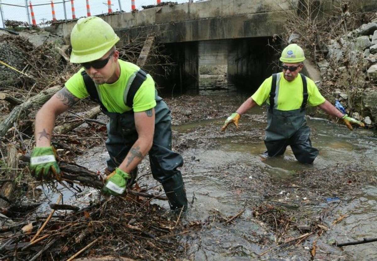 MoDot workers Clay LaPlante, left, and Jim Jamison clear debris from Fish Pot Creek in Ballwin, Mo., Wednesday, April 8, 2015, that was blocking the Manchester Road bridge near New Ballwin Road. The blockage came after the storm on Tuesday causing the area around the bridge to flood, including the Ballwin Auto Center and the Ballwin Laundromat. (AP Photo/St. Louis Post-Dispatch, J.B. Forbes) EDWARDSVILLE INTELLIGENCER OUT, THE ALTON TELEGRAPH OUT