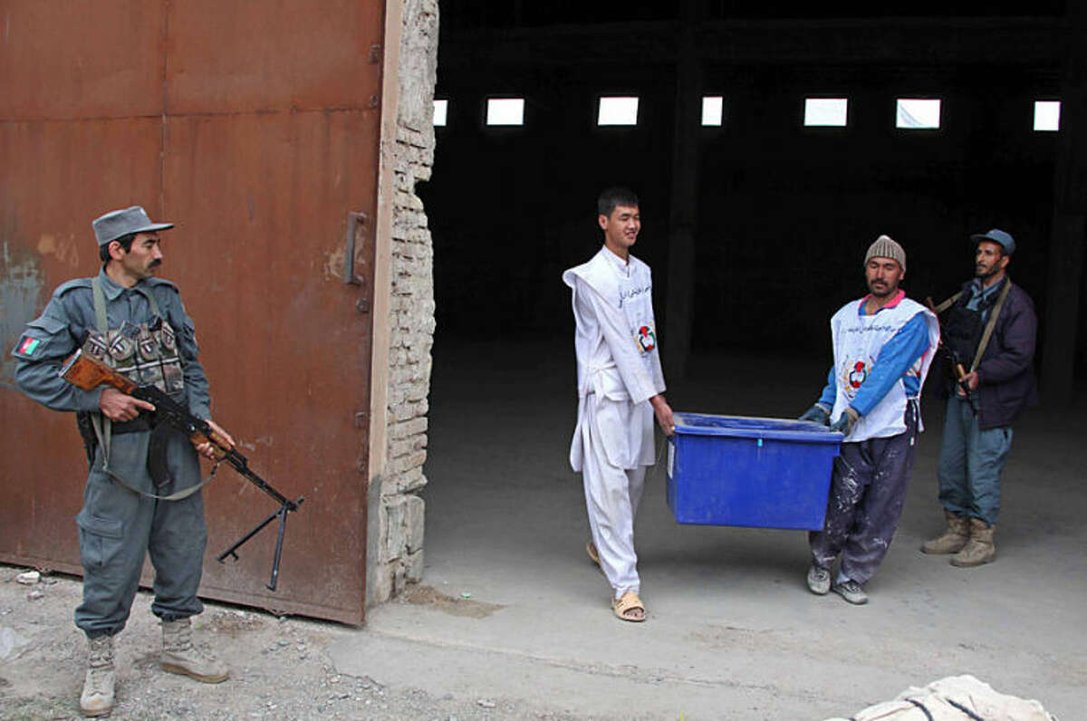 Afghan election workers prepare ballot boxes and election materials to be loaded into trucks and delivered to polling stations, at a warehouse in Herat, Afghanistan, Thursday, April 3, 2014. Elections will take place on Saturday. (AP Photo/Hoshang Hashimi)