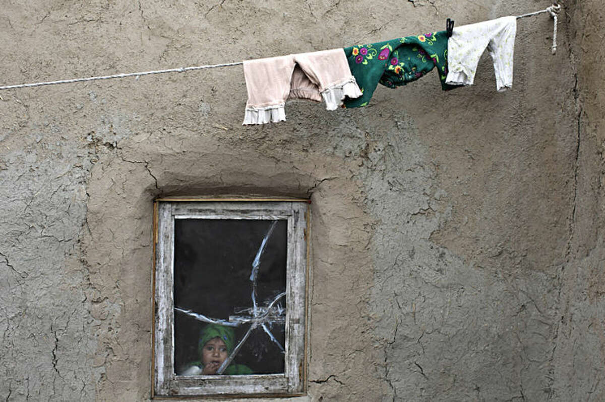 An Afghan girl looks out the window of her home in Kabul, Afghanistan, Thursday, April 3, 2014. (AP Photo/Muhammed Muheisen)