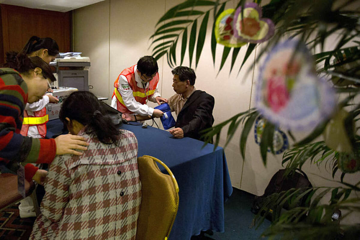 Relatives of the Chinese passengers onboard the Malaysia Airlines flight MH370 seek medical attention in a prayer room in Beijing Thursday, April 3, 2014. No trace of the Boeing 777 has been found nearly a month after it vanished in the early hours of March 8 on a flight from Kuala Lumpur to Beijing with 239 people on board. (AP Photo/Ng Han Guan)