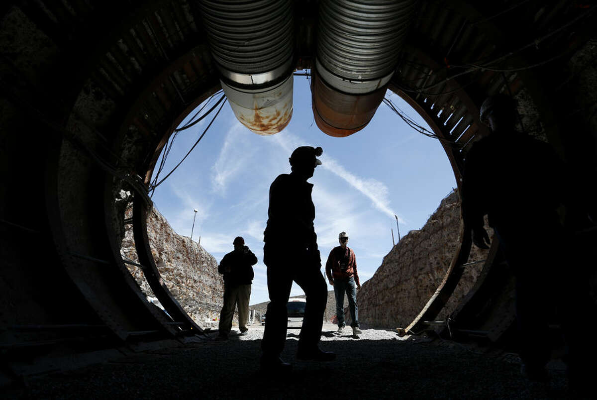 People walk into the south portal of Yucca Mountain during a congressional tour Thursday, April 9, 2015, near Mercury, Nev. Several members of Congress toured the proposed radioactive waste dump 90 miles northwest of Las Vegas. (AP Photo/John Locher)