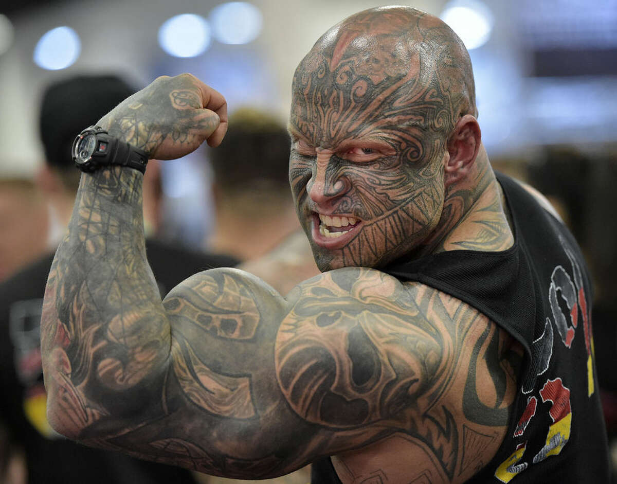 Bodybuilder Jens Dalsgaard from Denmark shows his muscles to visitors at the FIBO Power, a bodybuilding fair in Cologne, Germany, Thursday, April 9, 2015. (AP Photo/Martin Meissner)