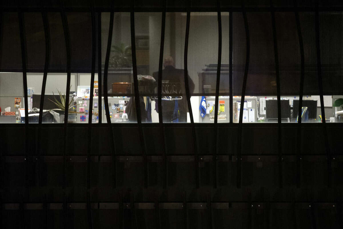A person is seen in a building on the U.S. Census Bureau headquarters campus as police search for an armed man who, according to a fire official, shot a security guard at a gate to the facility in Suitland, Md., Thursday, April 9, 2015. (AP Photo/Cliff Owen)