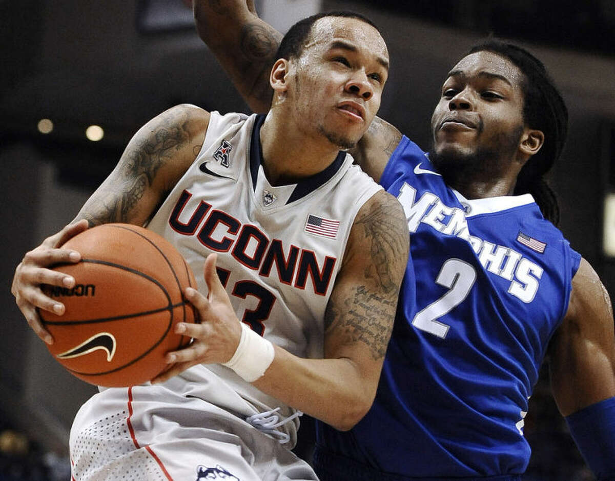 FILE - In this Feb. 15, 2014 file photo, Connecticut's Shabazz Napier, left, drives to the basket as Memphis' Shaq Goodwin defends during the second half an NCAA college basketball game in Hartford, Conn. Napier was selected to The Associated Press All-America team, released Monday, March 31, 2014. (AP Photo/Jessica Hill, FIle)