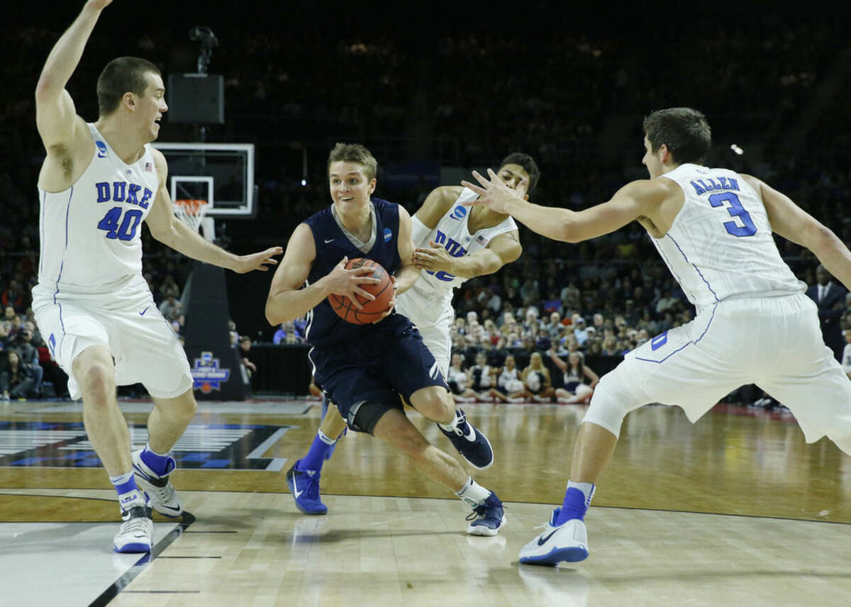 Yale's Makai Mason, center, drives between Duke's Marshall Plumlee (40) and Grayson Allen (3) during the first half in the second-round of the NCAA men's college basketball tournament in Providence, R.I., Saturday, March 19, 2016. (AP Photo/Michael Dwyer)