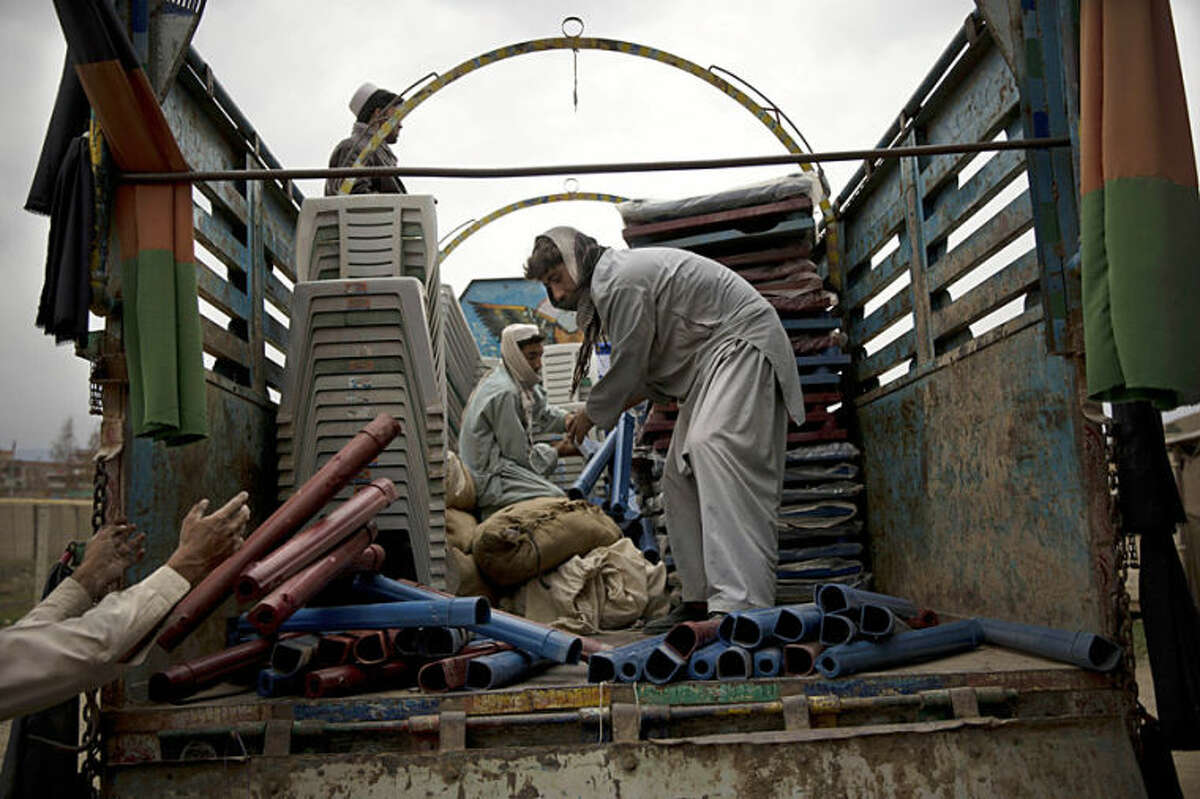 Afghan men load up a truck with office supplies and election materials to be delivered to election centers throughout the province in the eastern Afghan city of Khost, Thursday, April 3, 2014. Afghans go to the polls to elect a new President on April 5, 2014. (AP Photo/Anja Niedringhaus)