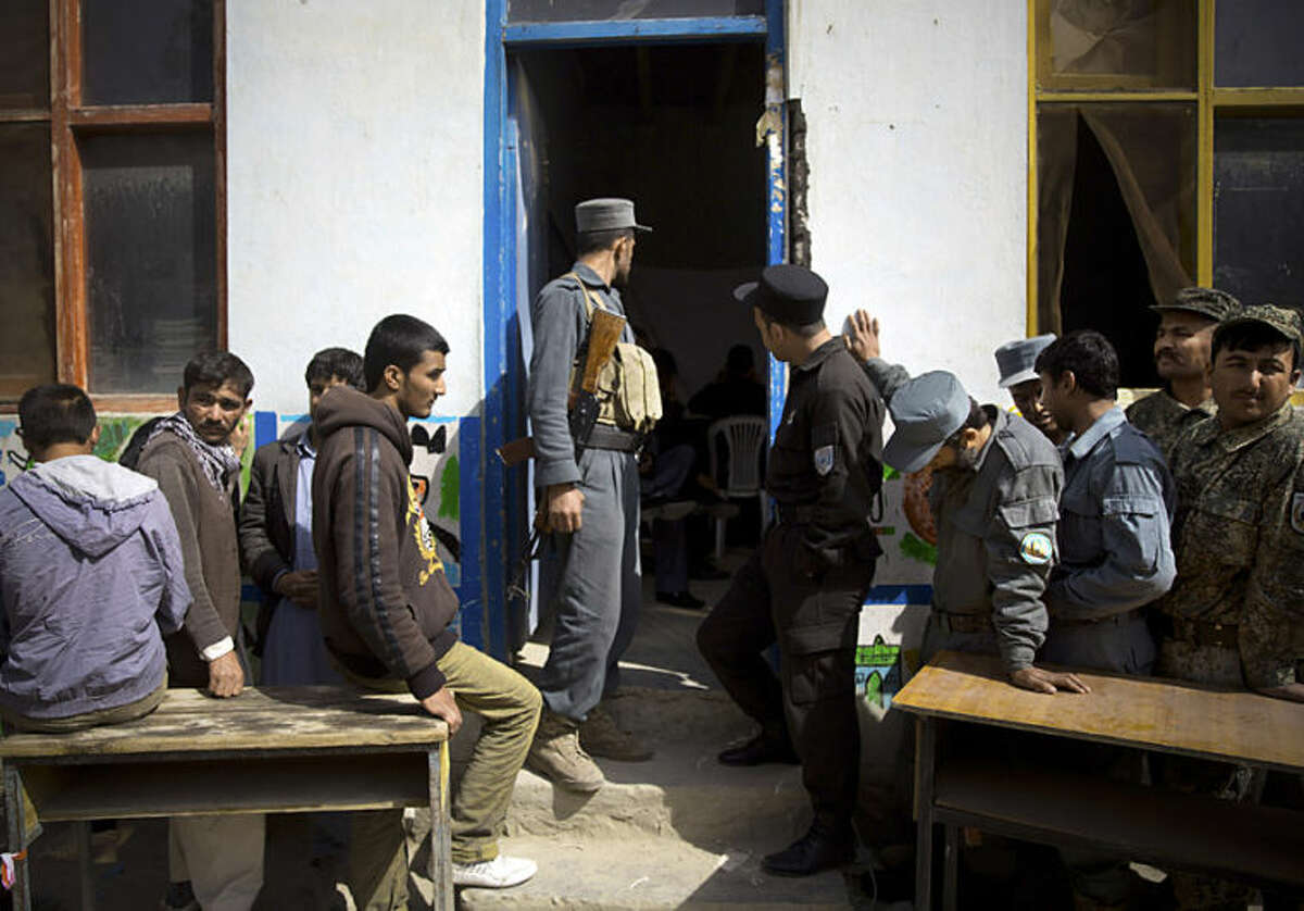 Afghan men wait in line to get their registration card on the last day of voter registration for the upcoming presidential elections outside a school in Kabul, Afghanistan, Tuesday, April 1, 2014. Elections will take place on April 5, 2014. (AP Photo/Anja Niedringhaus)