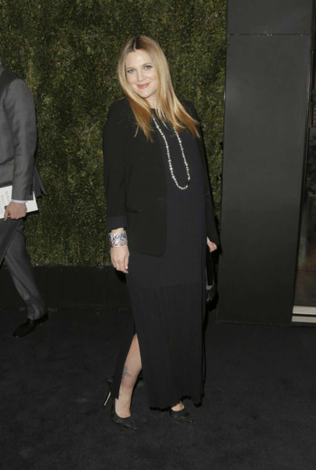FILE - In this Jan. 14, 2014 file photo, Drew Barrymore arrives at the Chanel Dinner celebrating the release of Drew Barrymore's new book "Find It In Everything" at the Chanel Boutique in Beverly Hills, Calif. The 39-year-old, who is expecting her second daughter with husband Will Kopelman any day now, is joining other famous families at Safe Kids Day, an educational playdate that raises funds and awareness of preventable childhood injuries. Gwen Stefani and Gavin Rossdale, Mark Wahlberg, Piers Morgan, Kelsey Grammer and Ciara are among the celebrities expected at the Los Angeles event Saturday, April 5, 2014. (Photo by Todd Williamson/Invision/AP, file)