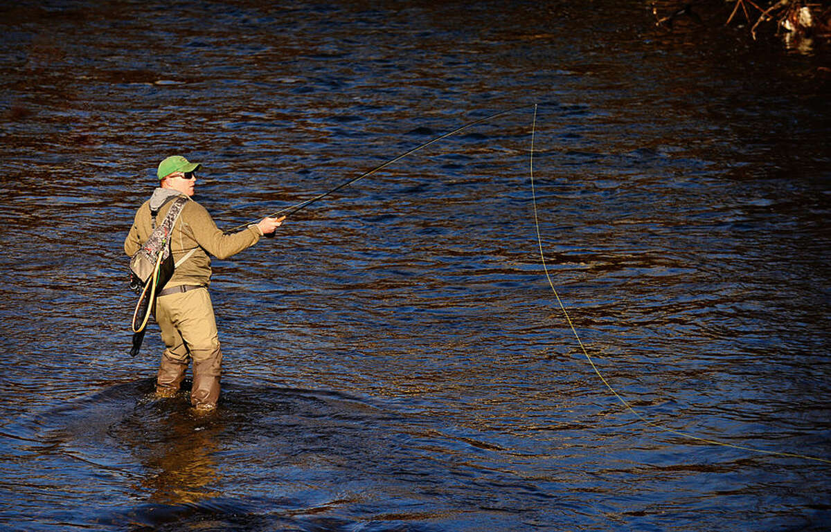 Hour photo / Erik Trautmann Local resident including Ben Couch fish for trout on the Norwalk River in Wilton on Opening Day Saturday.
