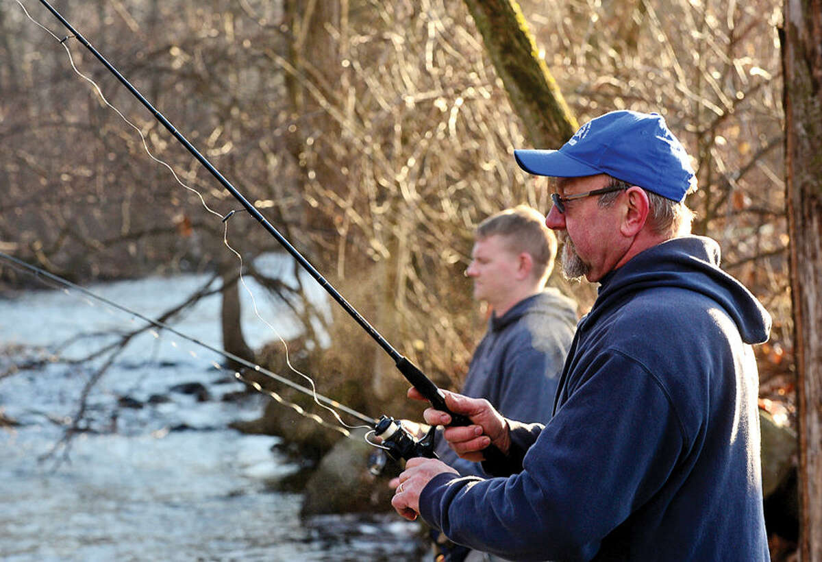 Hour photo / Erik Trautmann Local resident including Pete Delinski and his son Kevin fish for trout on the Norwalk River in Wilton on Opening Day Saturday.