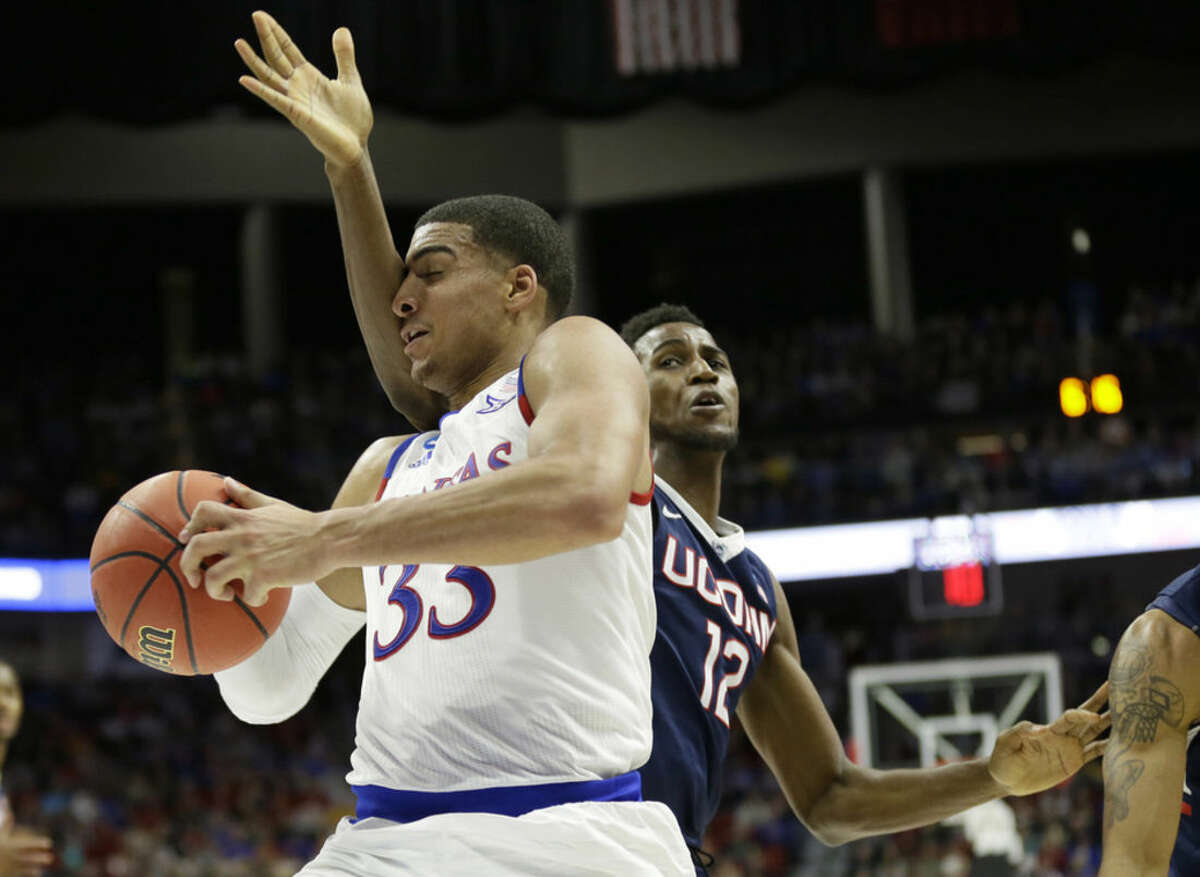 Kansas forward Landen Lucas drives past Connecticut forward Kentan Facey, right, during the first half of a second-round men's college basketball game in the NCAA Tournament, Saturday, March 19, 2016, in Des Moines, Iowa. (AP Photo/Charlie Neibergall)