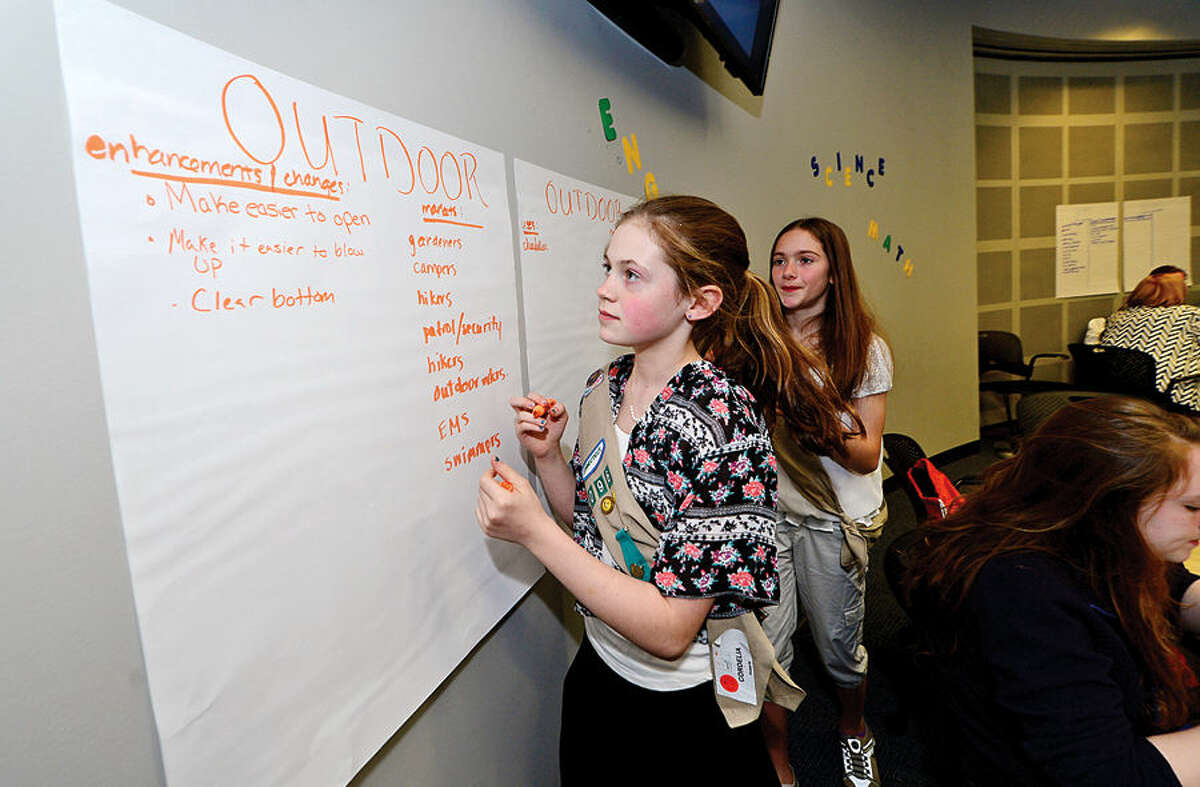 Hour photo / Erik Trautmann Girl Scouts Amelia Columbo and Cordelia Keberle work on their action plan as The International Womens Forum of Connecticut hosts a group of Girl Scouts at the UCONN School of Business in Stamford for an interactive workshop focused on STEM (Science Technology Engineering and Math) featuring the solar powered Luci Light. The girlscouts worked with leading executive women from across the state to form product development and marketing strategies for an enhanced Luci Light.