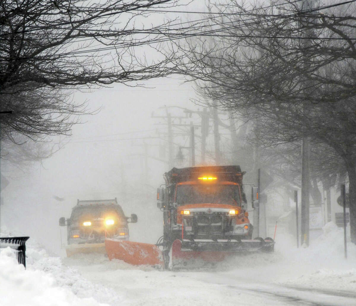 Plows move snow off Main street in Hyannis, Mass., Monday, Feb. 8, 2016. A wind-driven winter storm brought blizzard conditions to Cape Cod and threatened to drop up to 18 inches of snow on southeastern Massachusetts on Monday. (Ron Schloerb/The Cape Cod Times via AP)