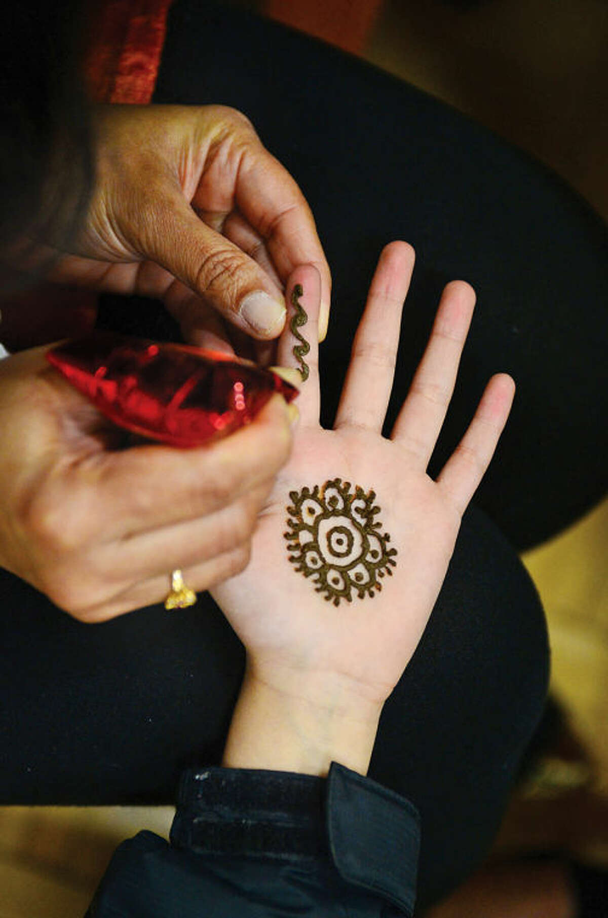Hour photo / Erik Trautmann Visitors had their hands painted with Henna during an Indian Spring Festival at the Wilton Family YMCA Saturday afternoon.