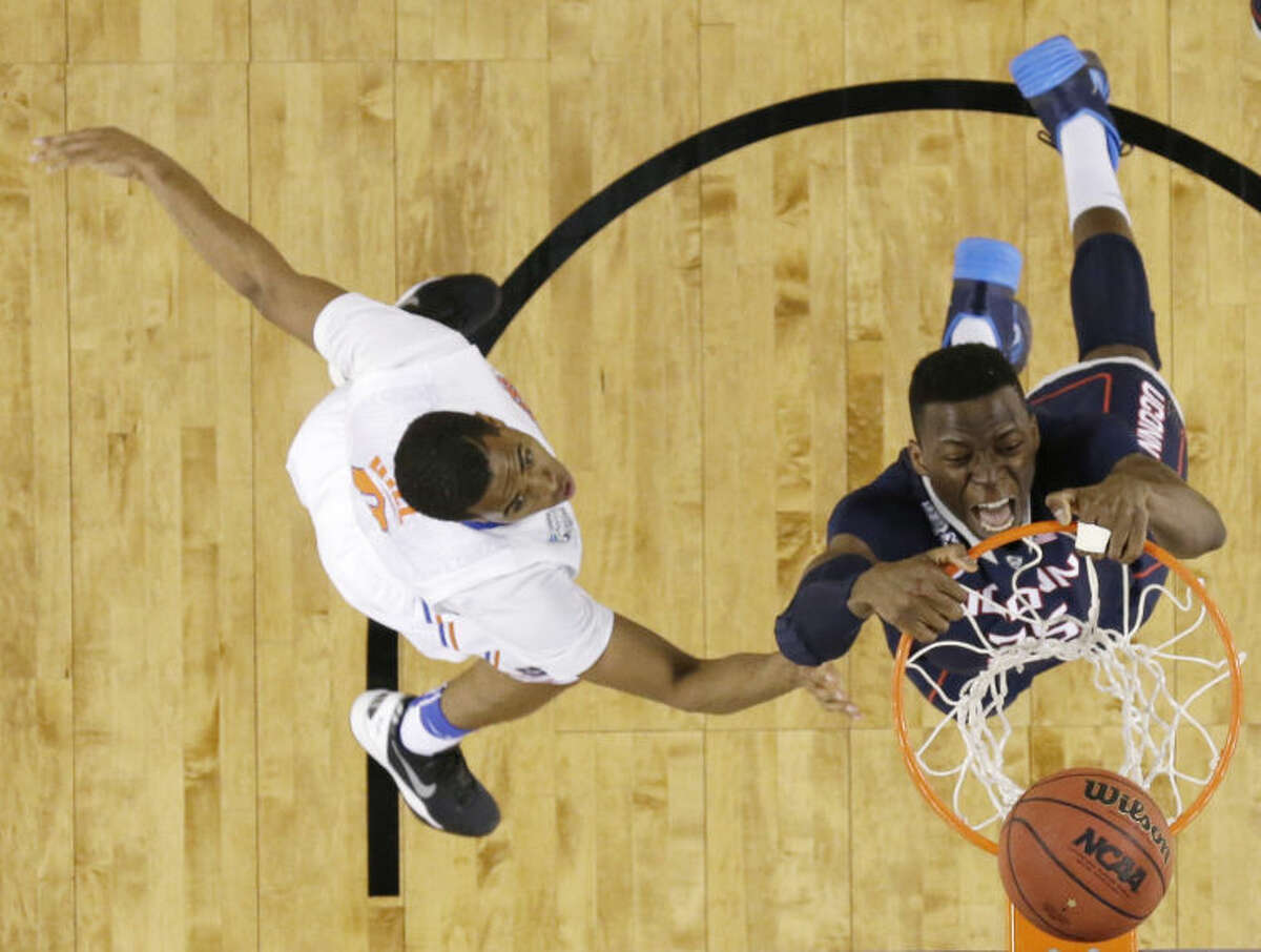 Connecticut center Amida Brimah, right, dunks the ball in front of Florida guard Kasey Hill during the second half of an NCAA Final Four tournament college basketball semifinal game Saturday, April 5, 2014, in Arlington, Texas. (AP Photo/David J. Phillip)