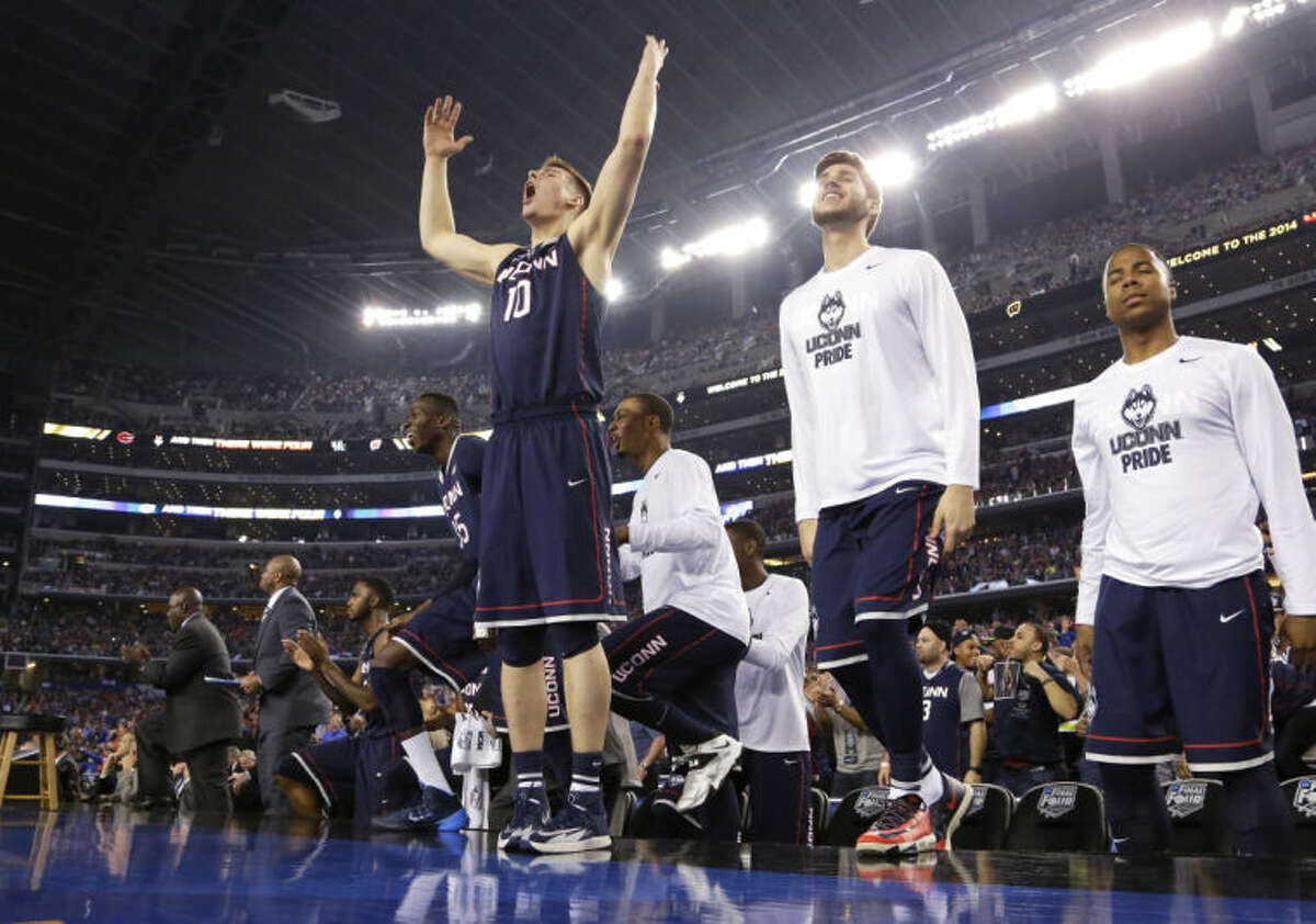 Connecticut forward Tyler Olander (10) celebrates with teammates at the end of an NCAA Final Four tournament college basketball semifinal game against Florida Saturday, April 5, 2014, in Arlington, Texas. Connecticut won 63-53. (AP Photo/Eric Gay)