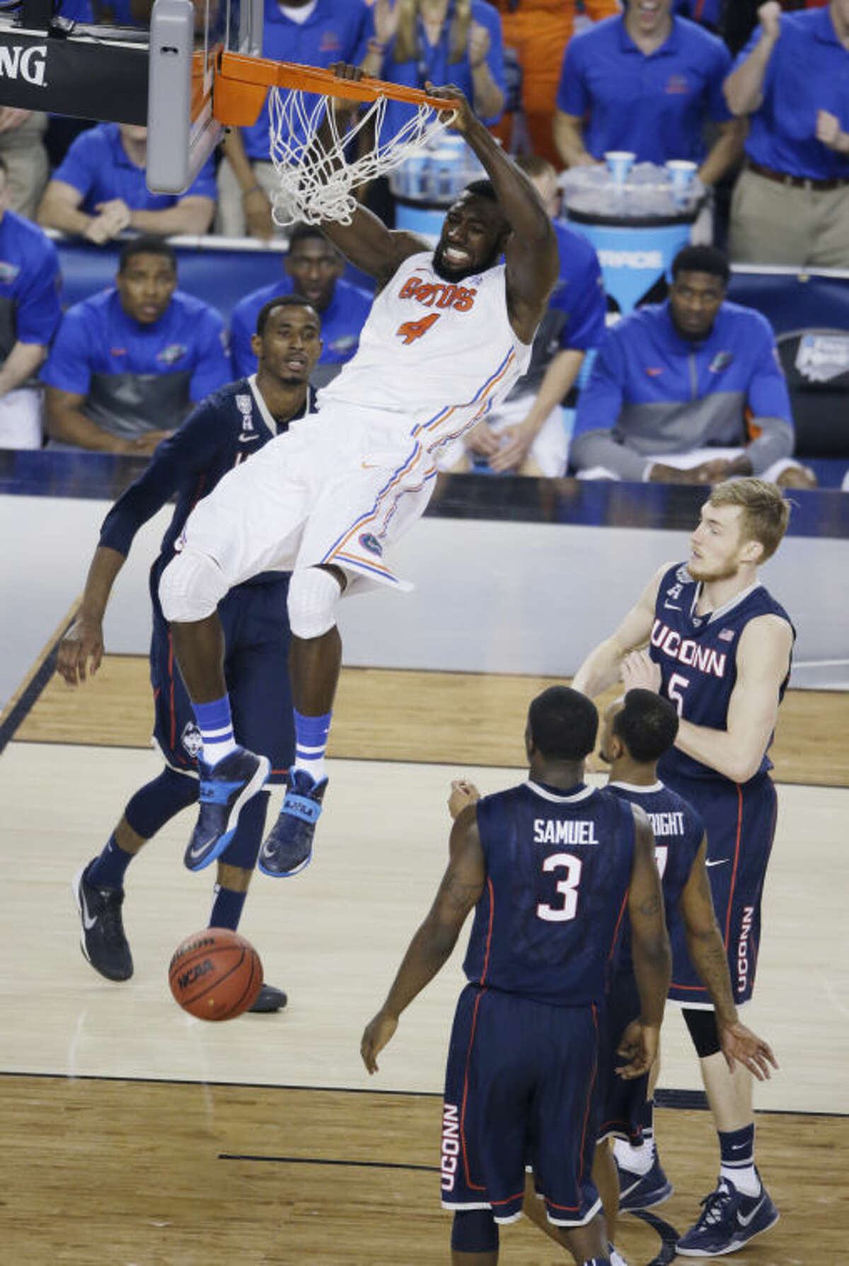 Florida center Patric Young (4) dunks the ball in front of Connecticut guard Terrence Samuel (3) during the second half of an NCAA Final Four tournament college basketball semifinal game Saturday, April 5, 2014, in Arlington, Texas. (AP Photo/Tony Gutierrez)