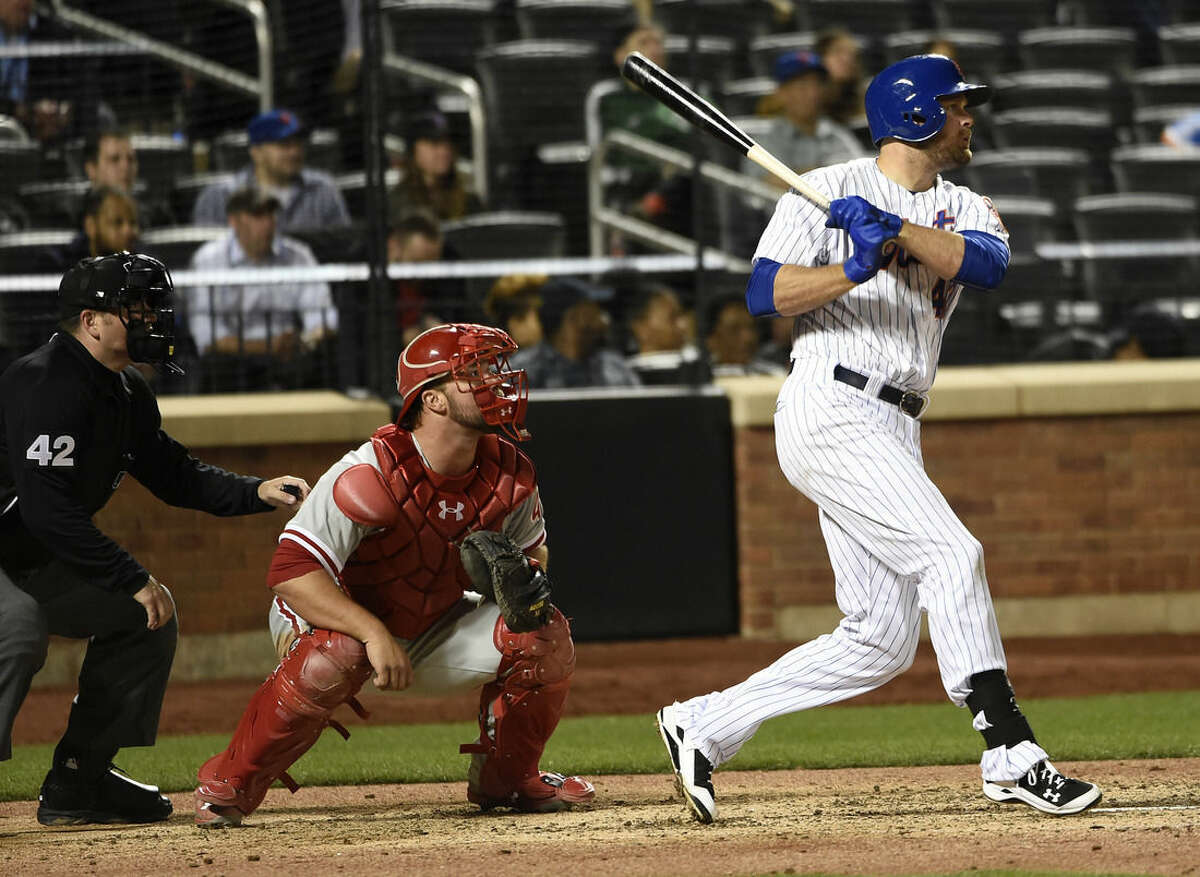 New York Mets first baseman Lucas Duda hits an RBI double in front of Philadelphia Phillies catcher Cameron Rupp in the sixth inning of a baseball game at Citi Field on Wednesday, April 15, 2015, in New York. (AP Photo/Kathy Kmonicek)