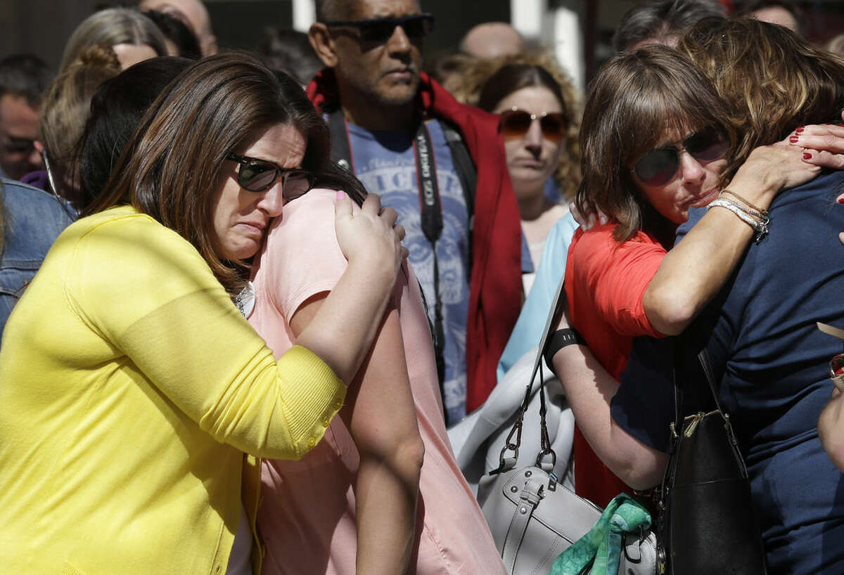 Jenna Dziedzic, of Boston, left, hugs Sabrina Dellorusso, also of Boston, second from left, as Linda Witt, of Neenah, Wis., second from right, hugs Jillian Boynton, of Manchester, N.H., right, during a moment of silence at one of two blast sites near the finish line of the Boston Marathon, in Boston, Wednesday, April 15, 2015. All four women were near the finish line of the Boston Marathon in 2013 where a friend, Roseann Sdoia, lost a limb during the explosion. (AP Photo/Steven Senne)