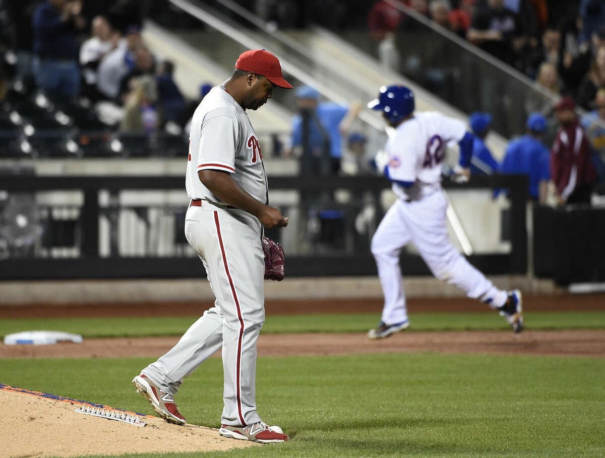 Philadelphia Phillies starting pitcher Jerome Williams, left, reacts on the mound as New York Mets Travis d'Arnaud rounds third base after hitting a solo home run in the third inning of a baseball game at Citi Field on Wednesday, April 15, 2015, in New York. (AP Photo/Kathy Kmonicek)