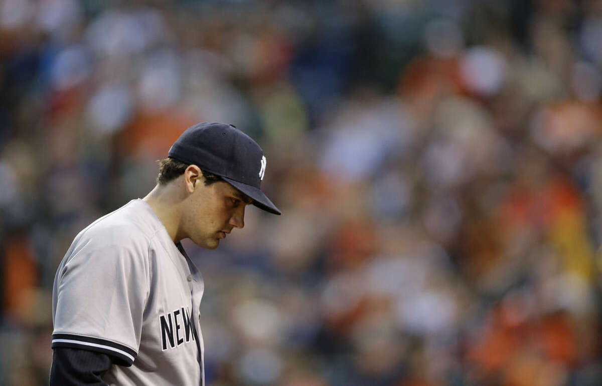 New York Yankees starting pitcher Nathan Eovaldi walks off the field at the end of the first inning of a baseball game against the Baltimore Orioles, Wednesday, April 15, 2015, in Baltimore. Baltimore scored a run against Eovaldi in the first. (AP Photo/Patrick Semansky)