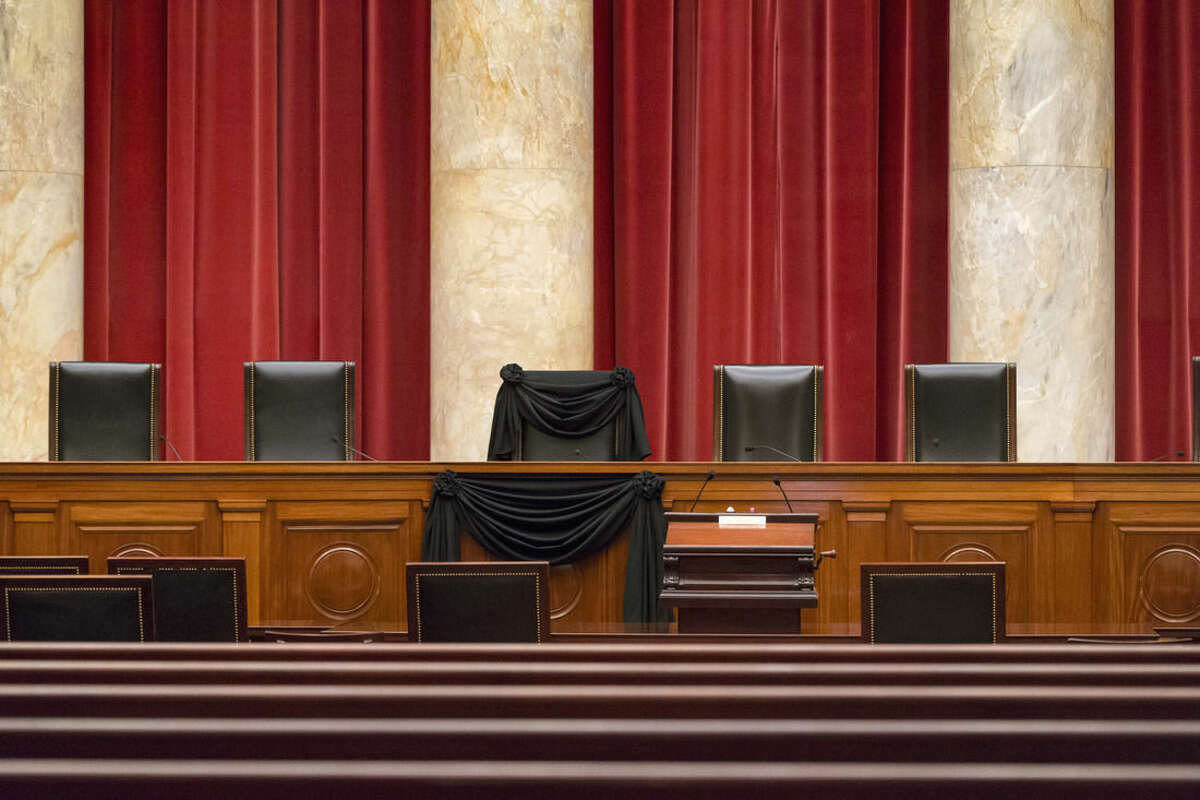 Supreme Court Justice Antonin Scalia’s courtroom chair is draped in black to mark his death as part of a tradition that dates to the 19th century, Tuesday, Feb. 16, 2016, at the Supreme Court in Washington. Scalia died Saturday at age 79. He joined the court in 1986 and was its longest-serving justice. (AP Photo/J. Scott Applewhite)