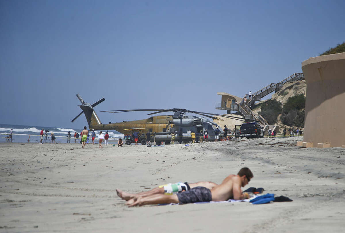 A Marine Corps helicopter sits in the sand where it made an emergency landing Wednesday, April 15, 2015 in Solana Beach, Calif. The CH-53E Super Stallion landed on the shore of this northern San Diego County town shortly after 11:30 a.m. after a low oil-pressure indicator light went on in the cockpit, Marine Corps Air Station Miramar said in a statement. (AP Photo/Lenny Ignelzi)