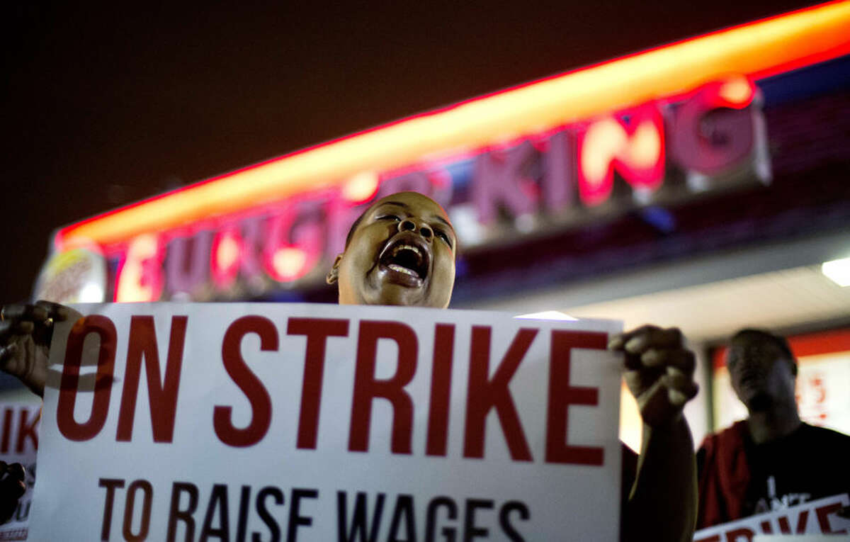 Fast food worker Qiana Shields chants during a demonstration outside a Burger King restaurant calling for the federal minimum wage to be raised to $15, Wednesday, April 15, 2015, in College Park, Ga. Organizers say they chose April 15, tax day, to demonstrate because they want the public to know that many low-wage workers must rely on public assistance to make ends meet. (AP Photo/David Goldman)